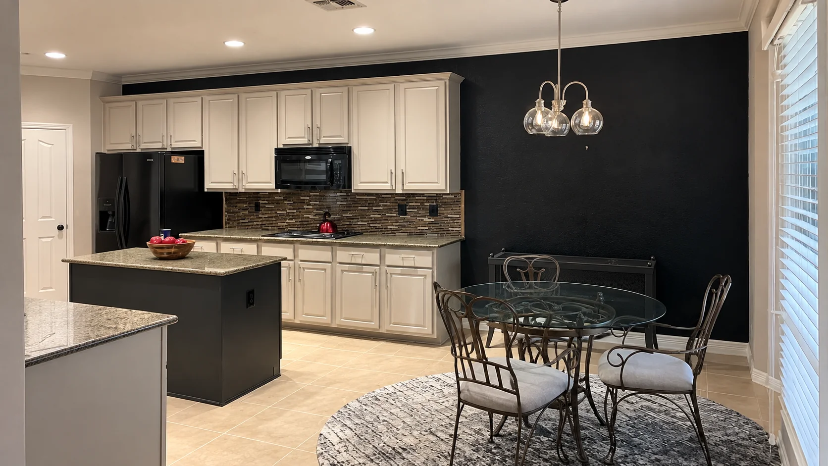 Finished kitchen and dining room with white cabinetry and black accent wall